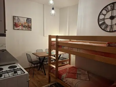 a room with a bunk bed and a kitchen with a clock at Apartments Ardoni in Ulcinj