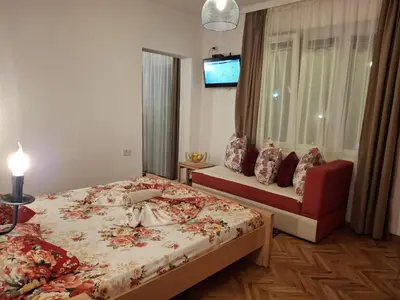 a bedroom with a bed and a window with a tv at Apartments Ardoni in Ulcinj