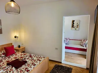 a small bedroom with a bed and a mirror at Apartments Ardoni in Ulcinj