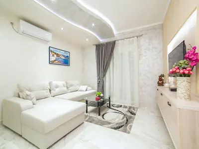 a living room with a white couch and a tv at Apartments Amigo in Kotor