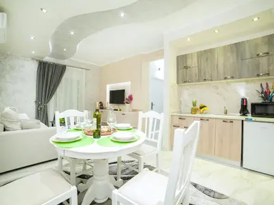 a kitchen and dining room with a white table and chairs at Apartments Amigo in Kotor