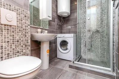 a bathroom with a toilet sink and a washing machine at Apartments Amigo in Kotor