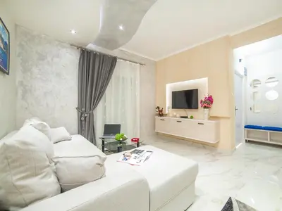 a living room with a white couch and a tv at Apartments Amigo in Kotor