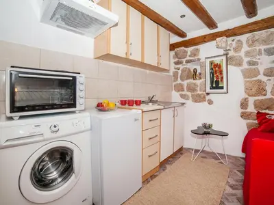 a kitchen with a washing machine and a microwave at Apartment Alexandra in Kotor