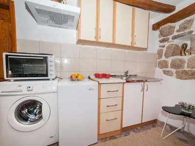 a kitchen with a washing machine and a microwave at Apartment Alexandra in Kotor