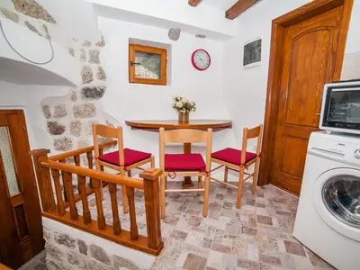 a kitchen with a table and chairs and a washing machine at Apartment Alexandra in Kotor