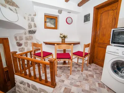 a kitchen with a table and chairs and a washing machine at Apartment Alexandra in Kotor