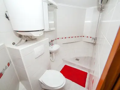 a white bathroom with a toilet and a sink at Apartment Alexandra in Kotor