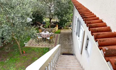 a balcony of a house with a table and chairs at Apartments & Rooms Jelka in Kotor