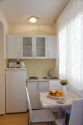 a kitchen with a table with a bowl of fruit on it at Apartments & Rooms Jelka in Kotor
