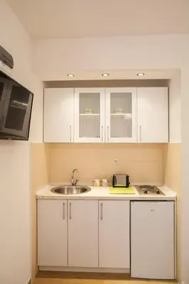 a kitchen with white cabinets and a sink at Apartments & Rooms Jelka in Kotor