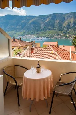 a table and chairs on a balcony with a view at Apartments & Rooms Jelka in Kotor