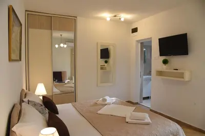 a room with a bed and a living room with a television at Apartments & Rooms Jelka in Kotor