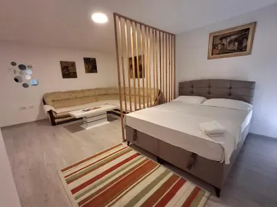 a bedroom with a bed and a couch at AS MONTENEGRO SUITES in Podgorica