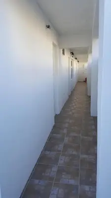 an empty hallway with white walls and a tile floor at AS MONTENEGRO SUITES in Podgorica