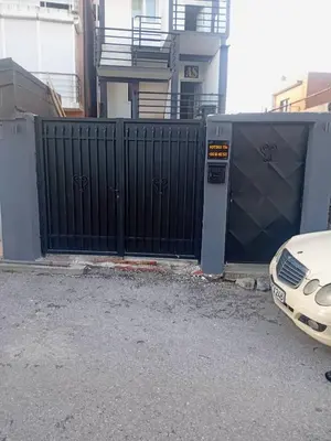a gate with a car parked in front of a building at AS MONTENEGRO SUITES in Podgorica
