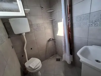 a small bathroom with a toilet and a sink at AS MONTENEGRO SUITES in Podgorica