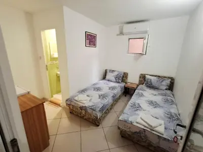a small room with two beds and a mirror at AS MONTENEGRO SUITES in Podgorica
