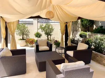 a patio with couches and chairs under a tent at Selena in Bar