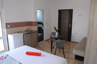 a room with a table and a kitchen with a sink at Apartments Flamida in Ulcinj