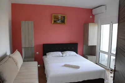 a red bedroom with a bed and a couch at Apartments Flamida in Ulcinj