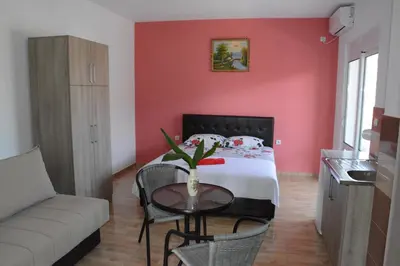 a bedroom with a bed and a table and a couch at Apartments Flamida in Ulcinj