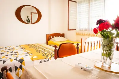 a room with a bed and a table with a vase of flowers at Etno House Mira in Virpazar