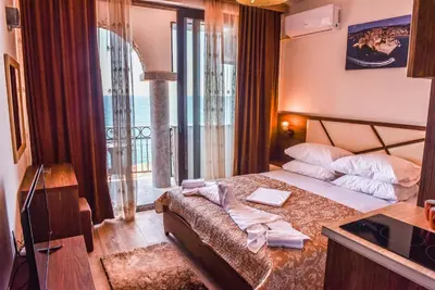 a hotel room with a bed with a balcony at Apartments Timoni in Ulcinj
