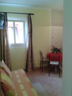 a bedroom with a table and a window and a table and chair at Guesthouse Lautasevic in Petrovac na Moru