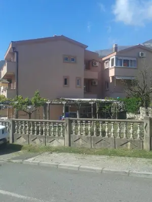 a wooden fence in front of a building at Guesthouse Lautasevic in Petrovac na Moru