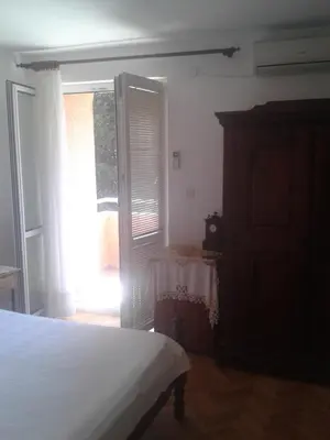 a bedroom with a bed and a window and a dresser at Guesthouse Lautasevic in Petrovac na Moru