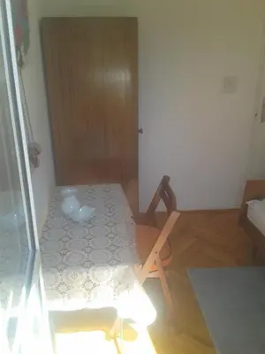a room with a table and a wooden chair at Guesthouse Lautasevic in Petrovac na Moru