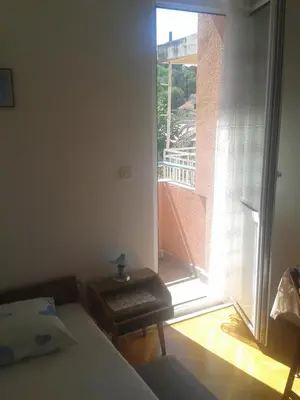a bedroom with a bed and a view of a balcony at Guesthouse Lautasevic in Petrovac na Moru