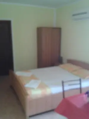 a bedroom with a bed and a wooden cabinet at Guesthouse Lautasevic in Petrovac na Moru