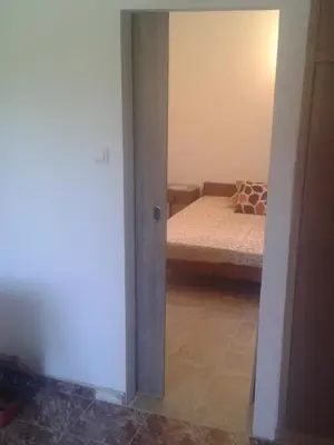 a bedroom with a bed and a room with a door at Guesthouse Lautasevic in Petrovac na Moru