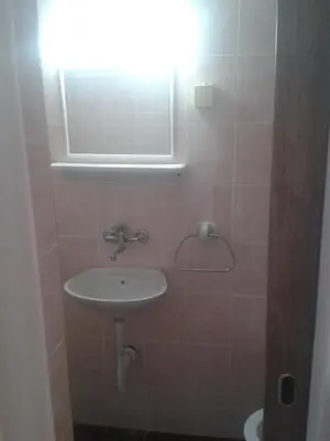 a bathroom with a sink and a light on the wall at Guesthouse Lautasevic in Petrovac na Moru