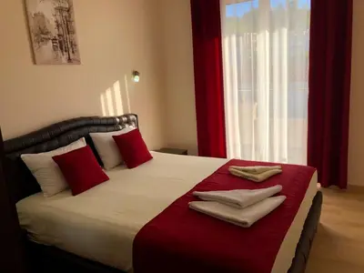 a bedroom with a large bed with red and white pillows at Moonlight Apartments in Ulcinj