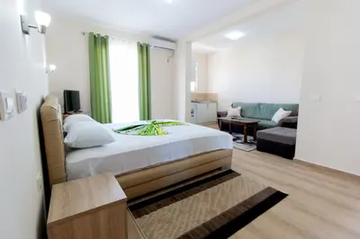 a bedroom with a large bed and a living room at Moonlight Apartments in Ulcinj