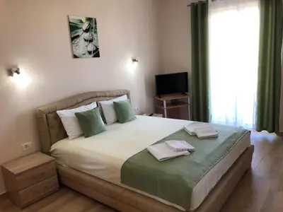a bedroom with a large bed with two towels on it at Moonlight Apartments in Ulcinj