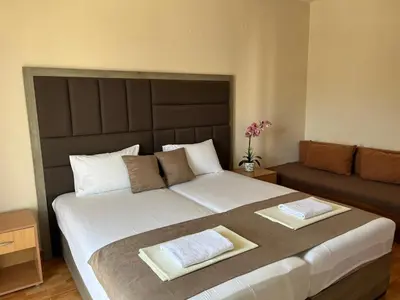 a bedroom with a large bed and a couch at Moonlight Apartments in Ulcinj