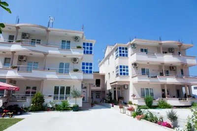 a large white apartment building with a driveway at Moonlight Apartments in Ulcinj