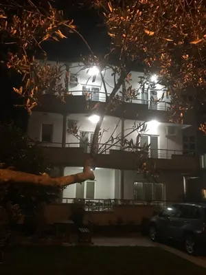 a building at night with a car parked in front at Moonlight Apartments in Ulcinj
