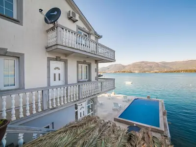 a house with a balcony and a swimming pool at Apartments Elena in Tivat