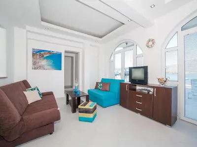 a living room with a couch and a tv at Apartments Elena in Tivat