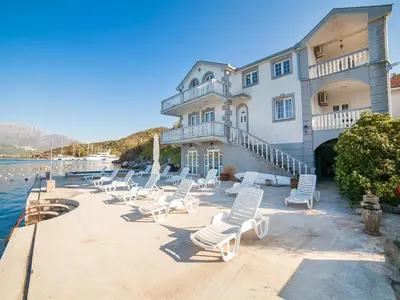 a group of chairs sitting in front of a building at Apartments Elena in Tivat