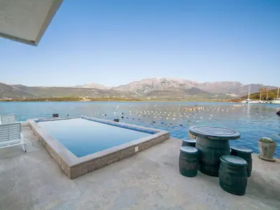 a swimming pool sitting next to a body of water at Apartments Elena in Tivat