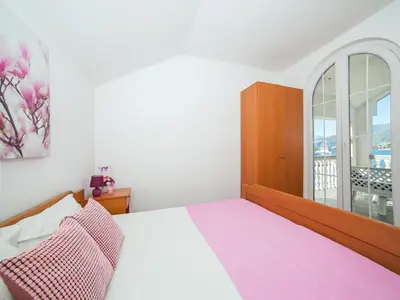 a bedroom with a bed and a large window at Apartments Elena in Tivat