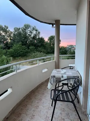 a balcony with a table and a view of trees at Studio Apartments Domenik in Ulcinj
