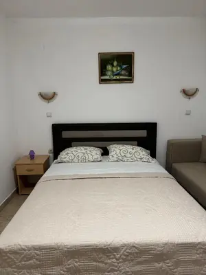 a bedroom with a large bed and a couch at Studio Apartments Domenik in Ulcinj