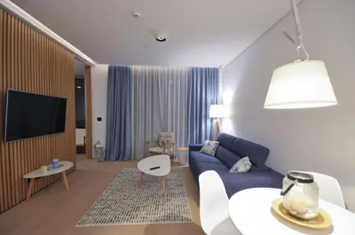 a living room with a blue couch and a table at Leona Residences Apartment in Budva